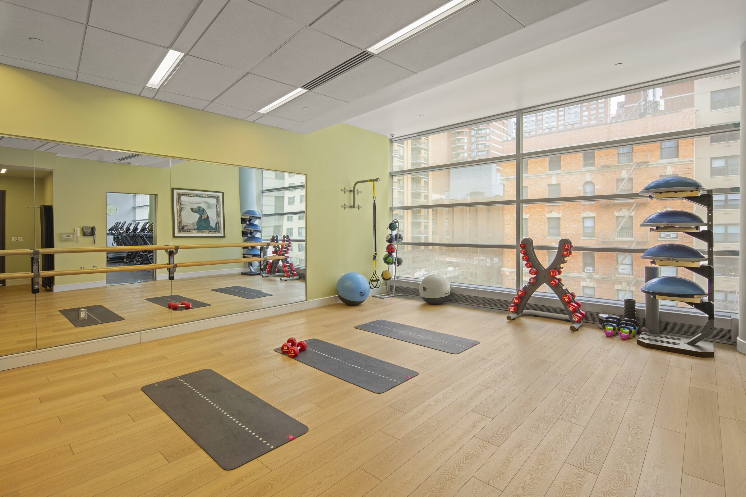 Yoga studio at AIRE with mats, exercise equipment, and city views