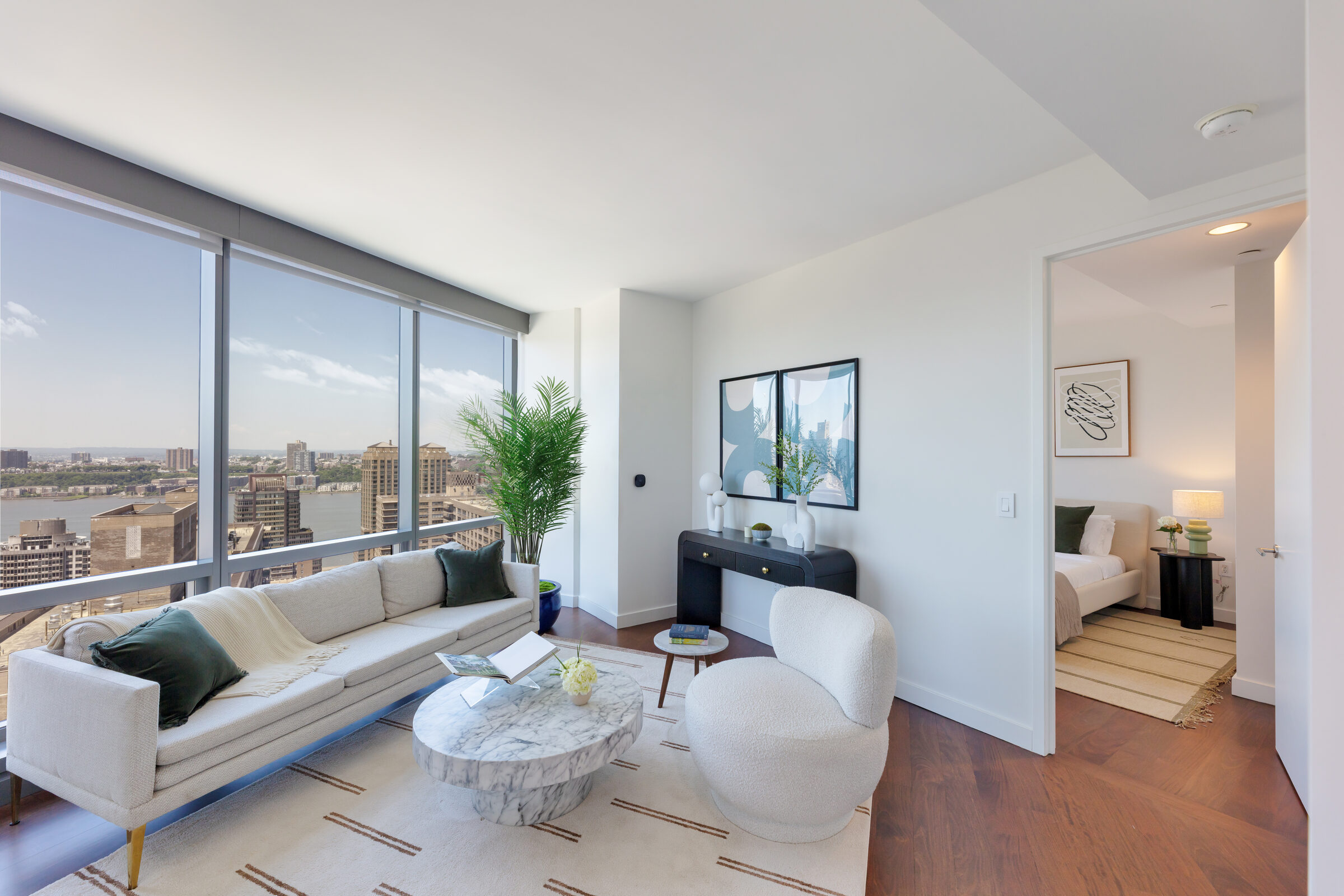 Living room at AIRE with floor-to-ceiling windows overlooking the Hudson River