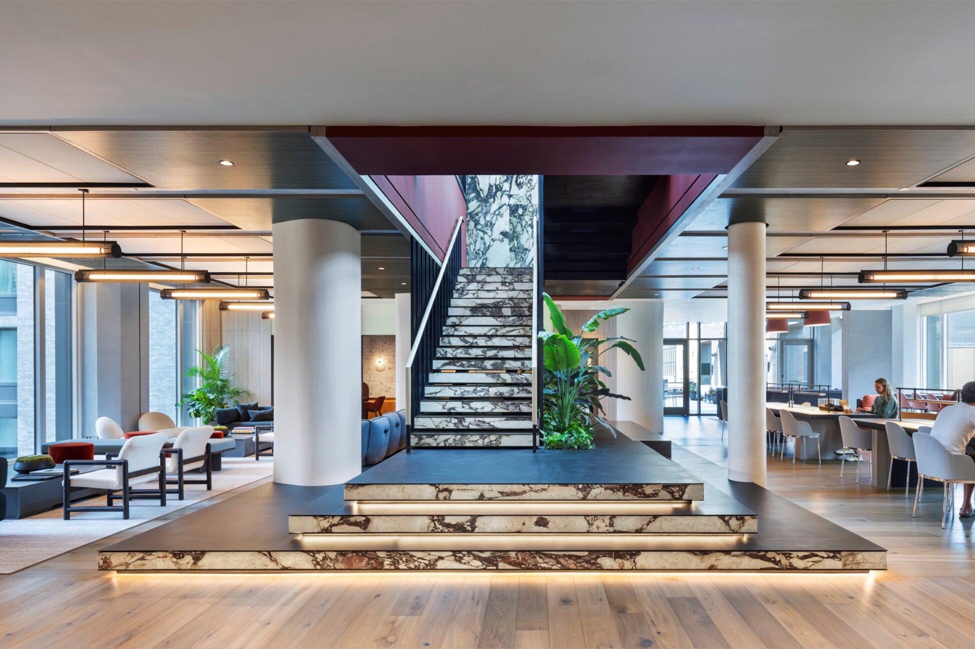 Multi-level resident lounge with a central staircase and communal seating