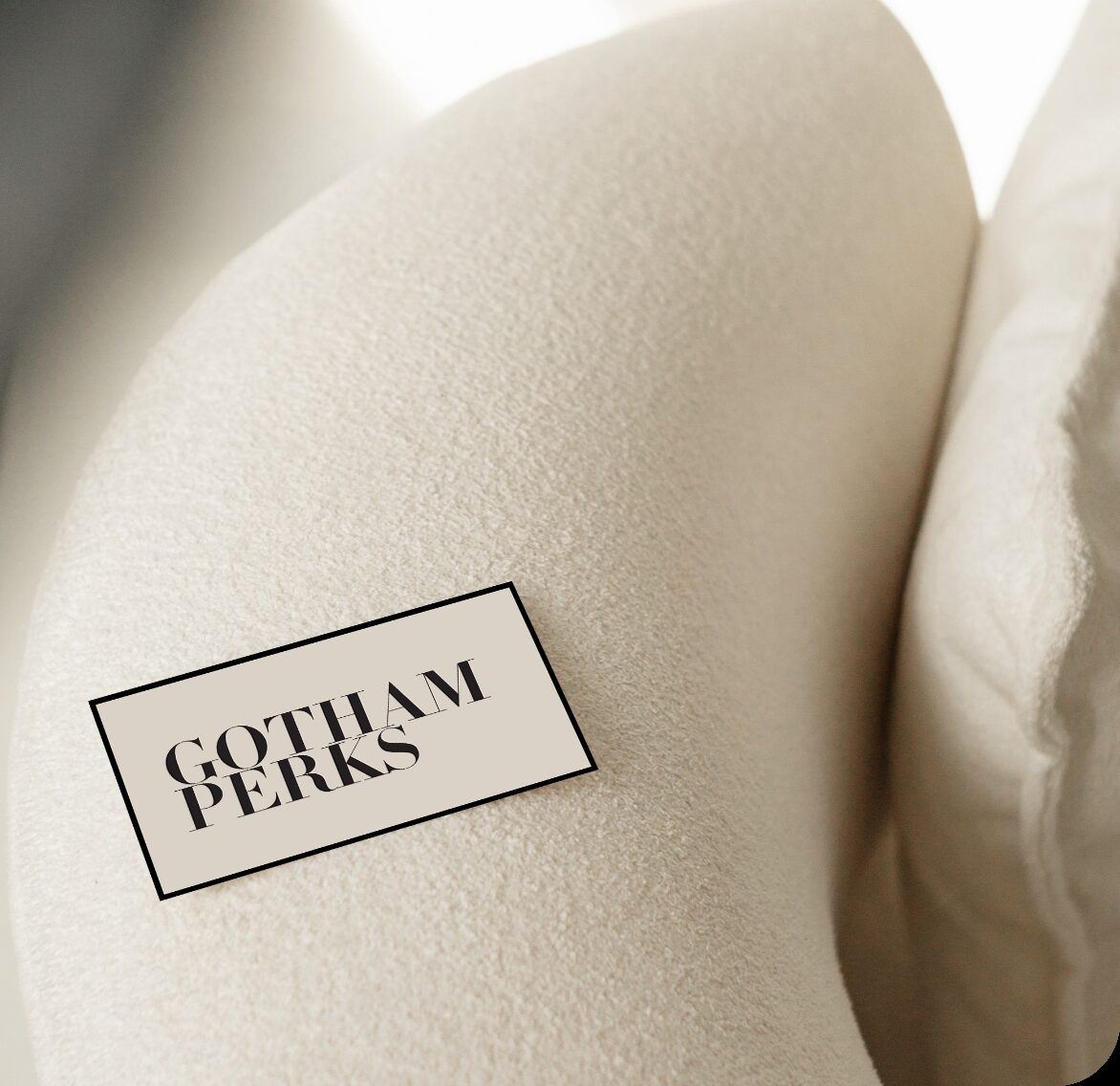 Gotham Perks card resting on a cream-colored cushion