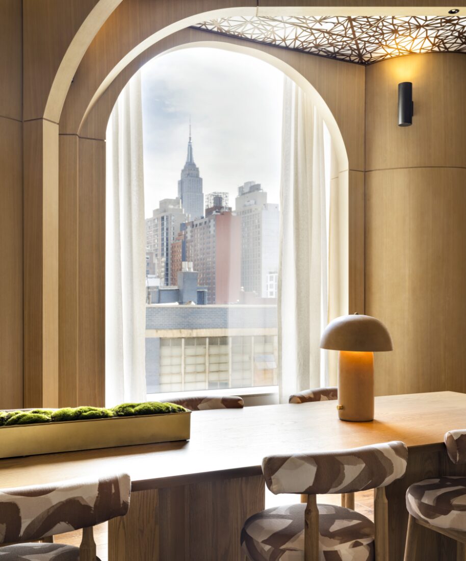 Workspace framed by an arched window with an Empire State Building view