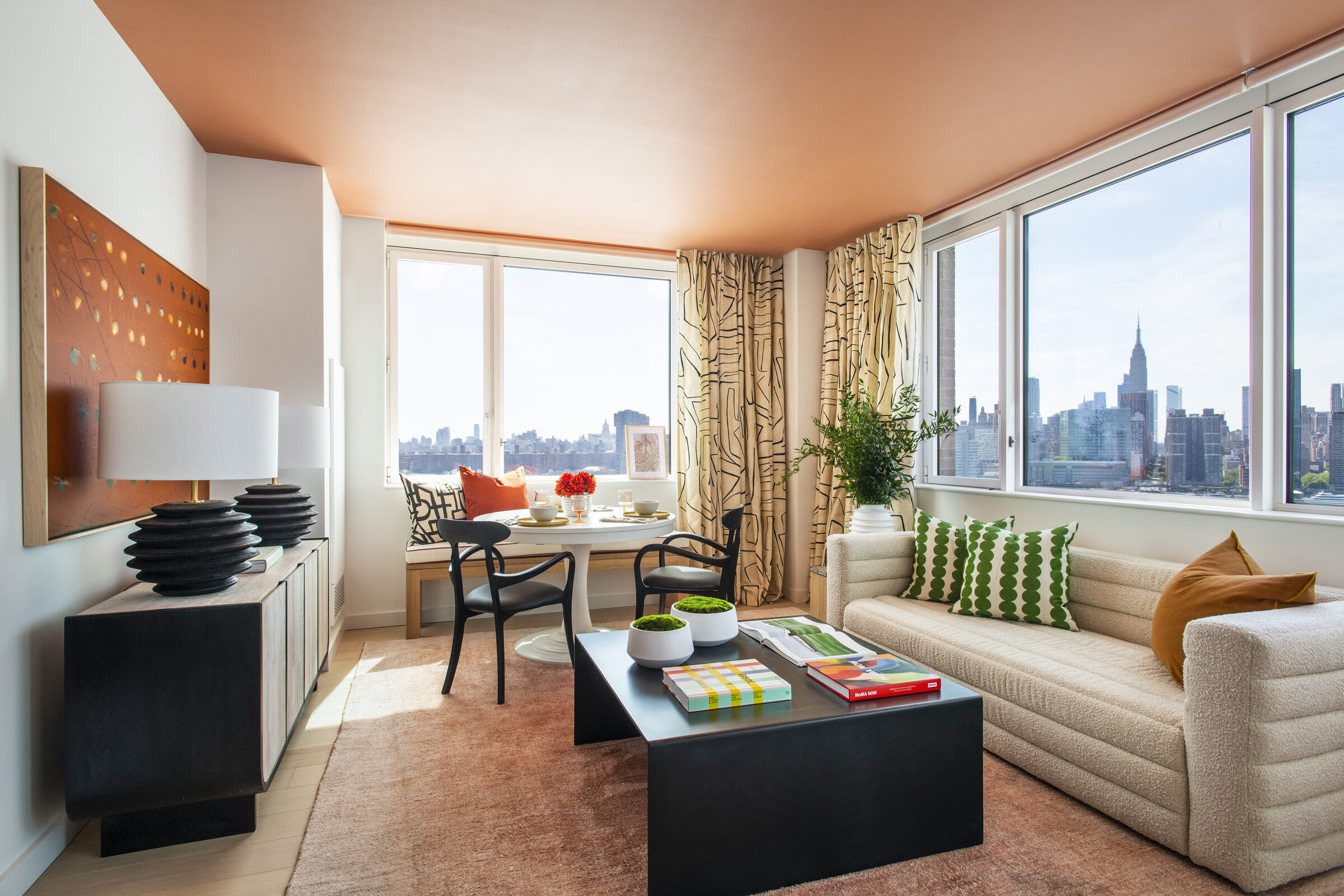Sunlit living and dining room at Gotham Point with Manhattan skyline views