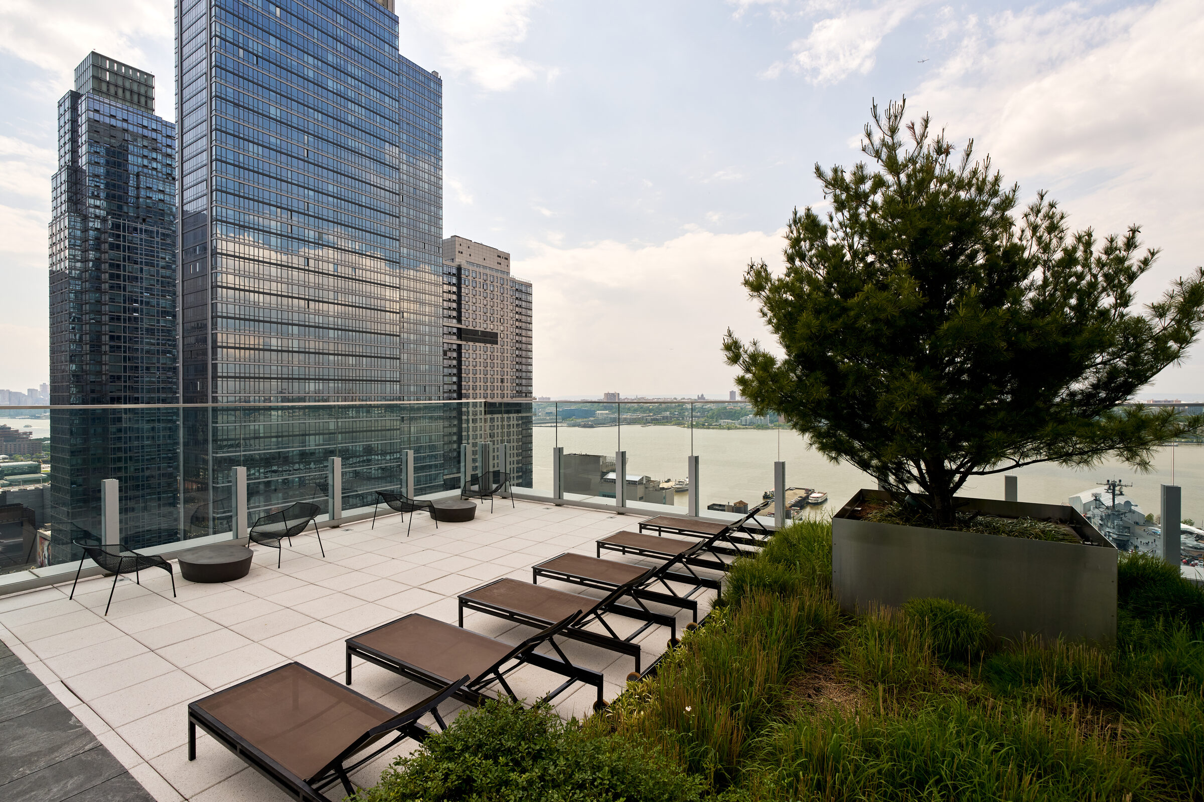 Landscaped rooftop sun deck at Gotham West overlooking the Hudson River
