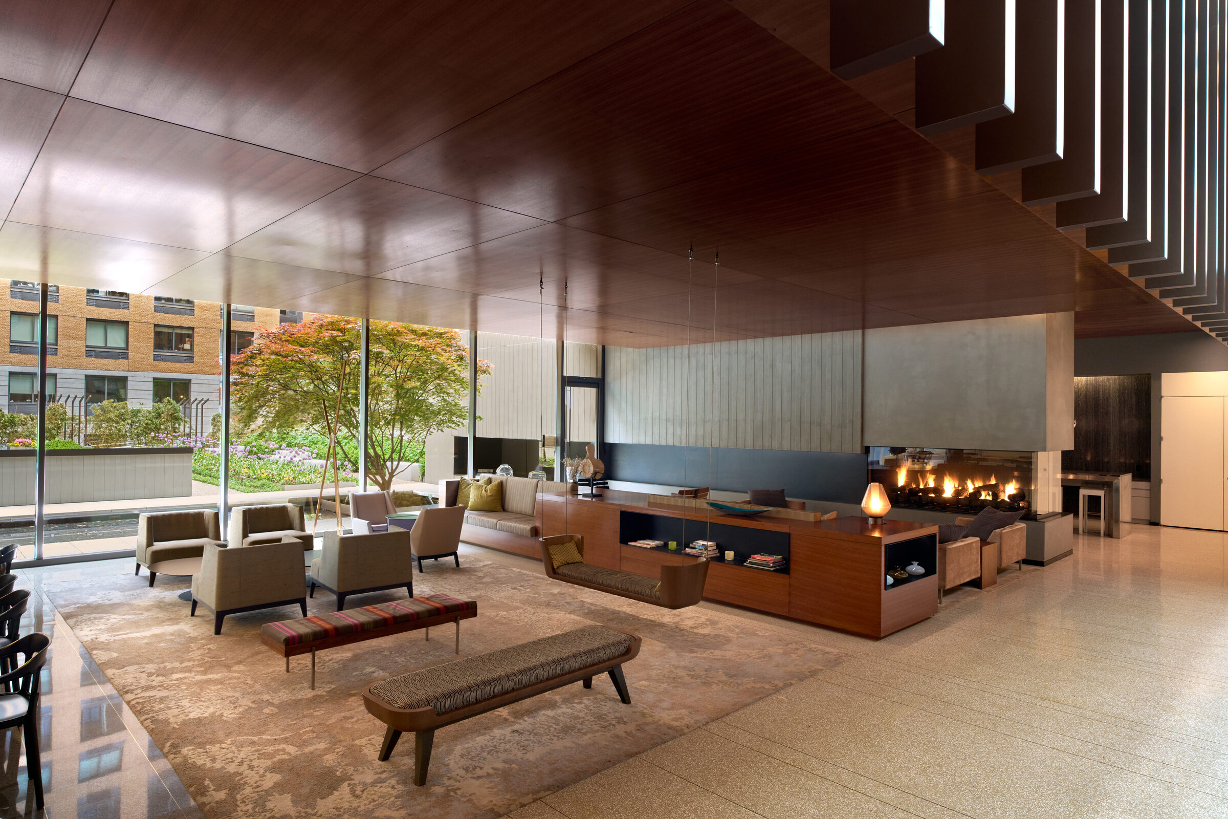 Wood-paneled resident lounge at Gotham West with a fireplace