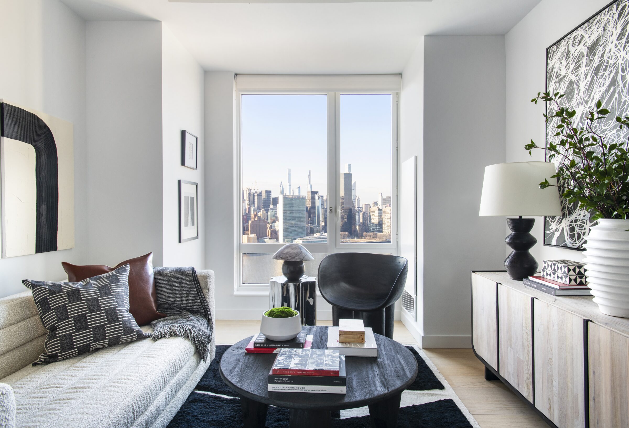 Sunlit Gotham Point living room with floor-to-ceiling windows and skyline views