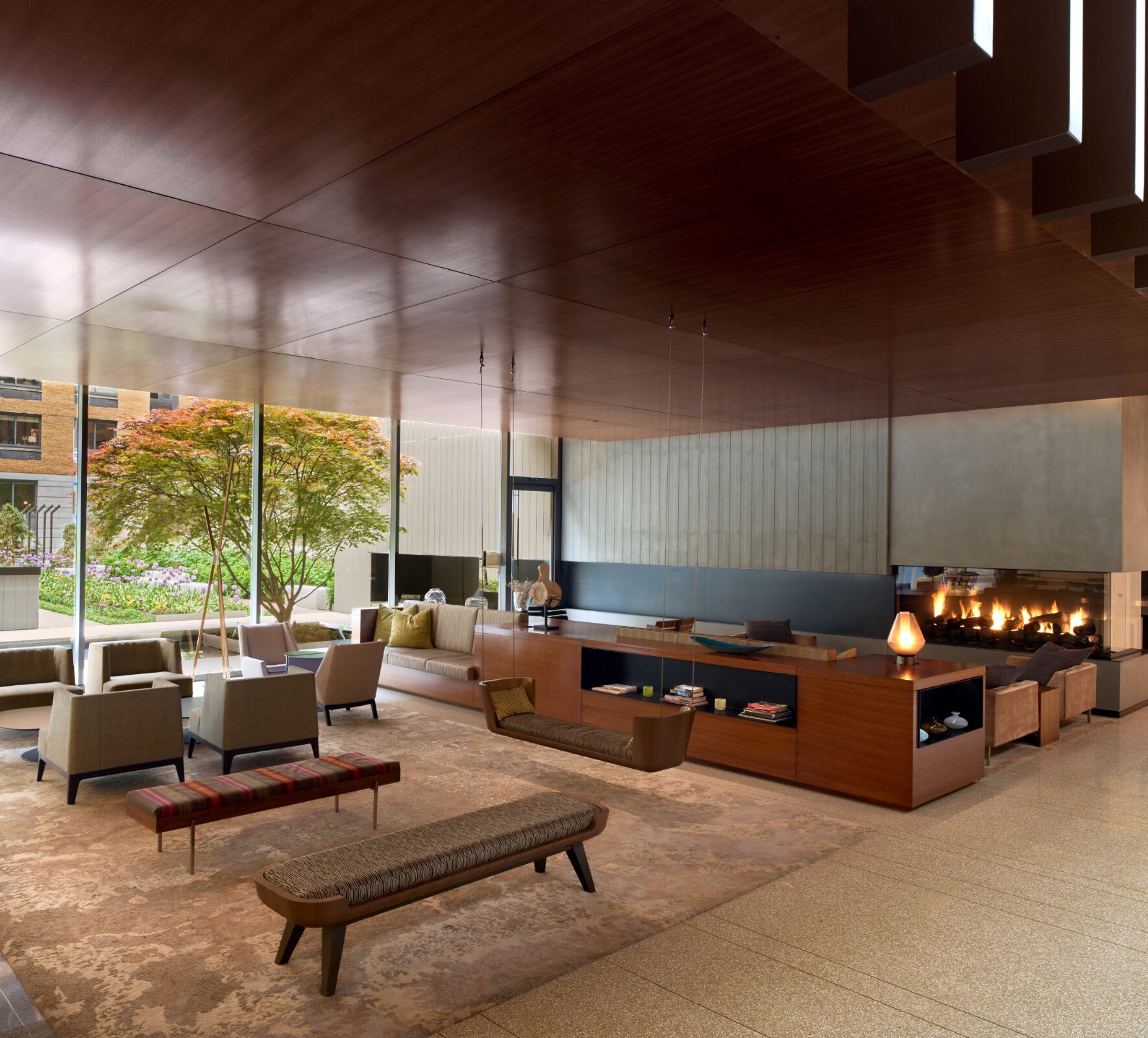 Resident lounge at Gotham West with a fireplace and garden views