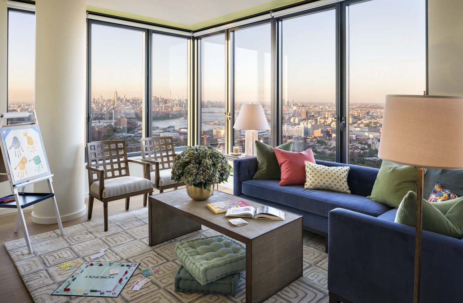 Sunlit corner living room at The Ashland with floor-to-ceiling windows and city views
