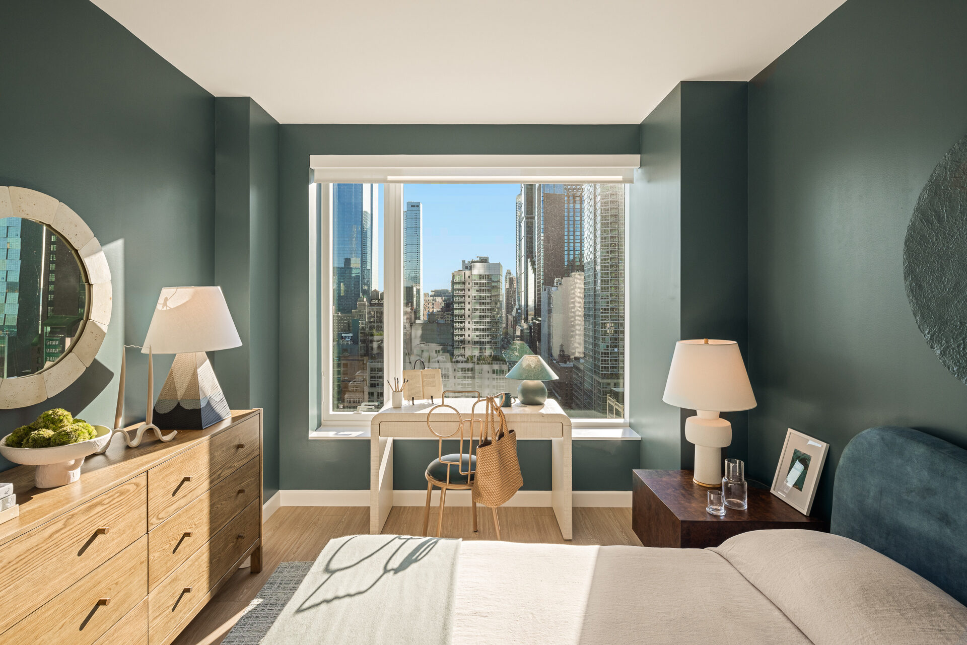 Furnished bedroom at The Maybury with a window-facing desk and Manhattan skyline views