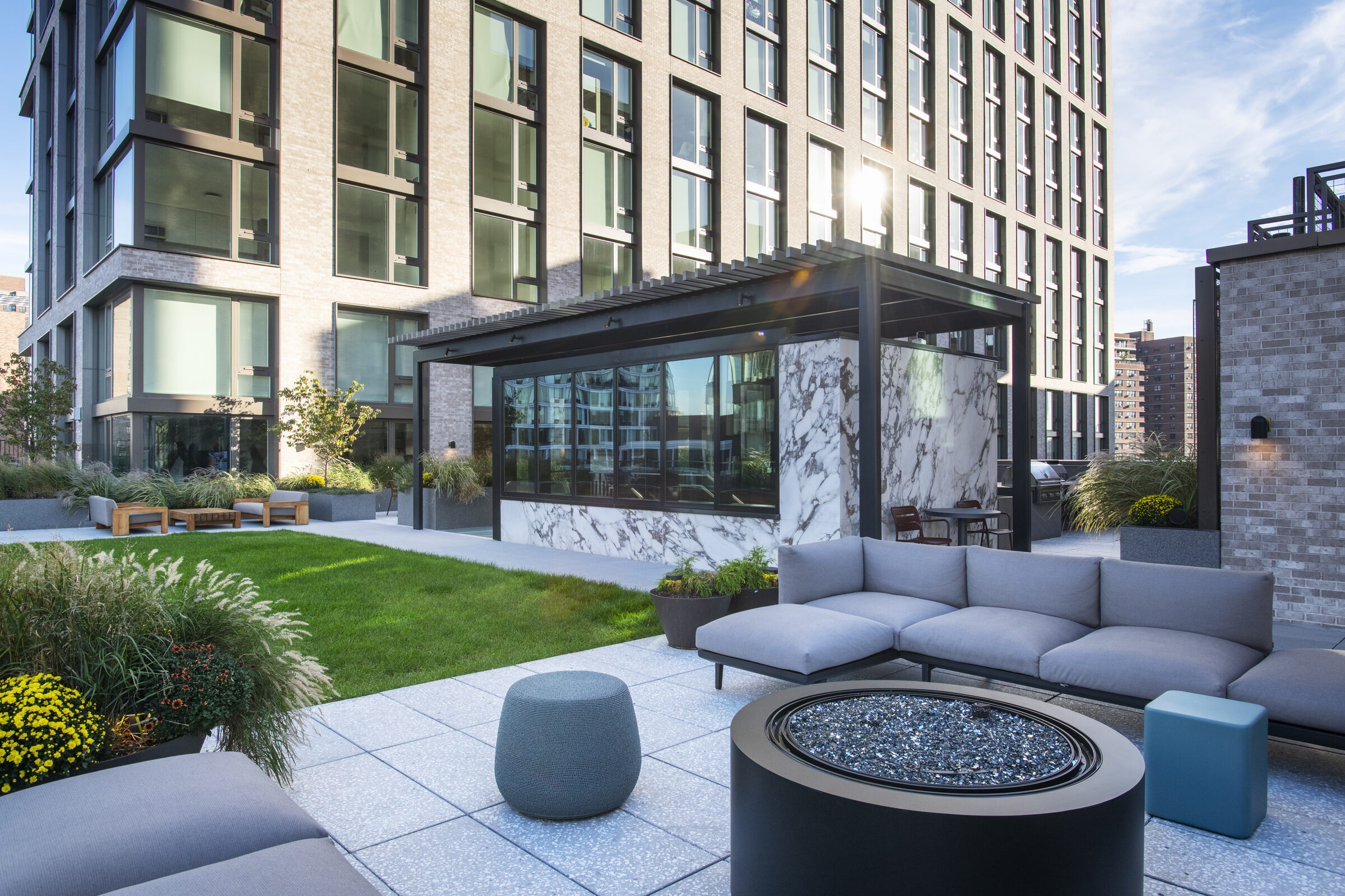 Landscaped courtyard at The Suffolk with lounge seating and a fire pit