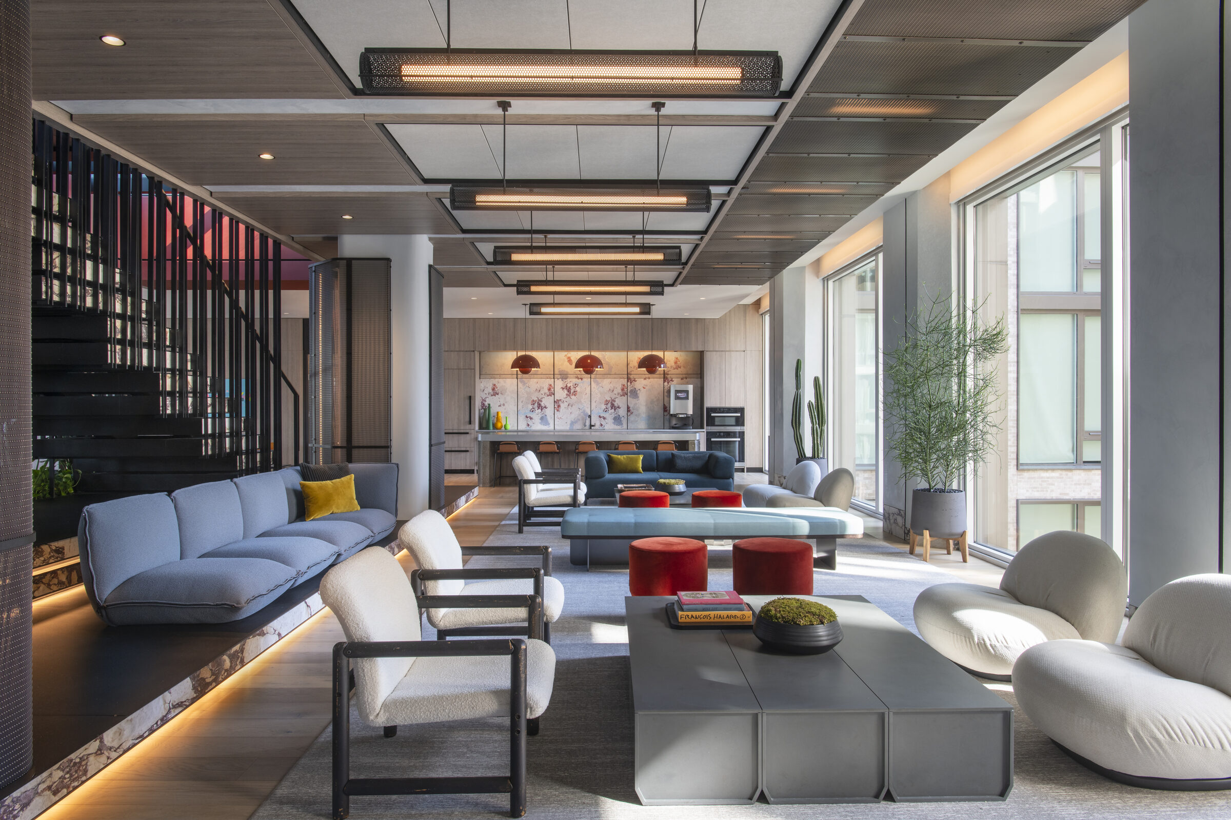 Resident lounge at The Suffolk with a staircase and multiple seating areas