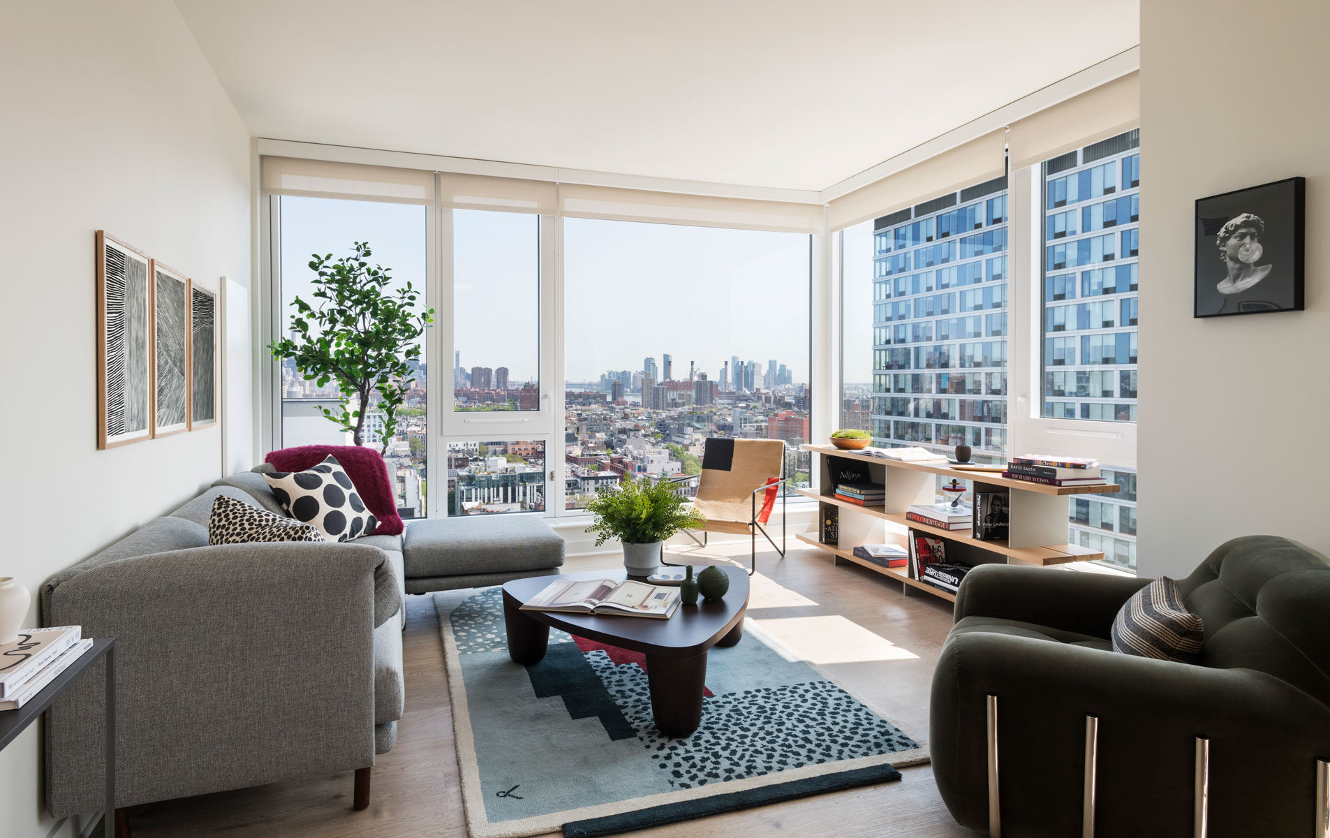 Sunlit living room at The Suffolk with floor-to-ceiling windows and city views